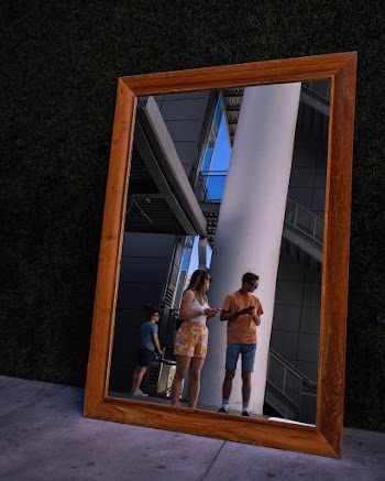 Photo of a Rectangular Mirror Reflecting Standing People
