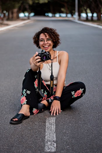 Photo of a Smiling Woman Holding Camera