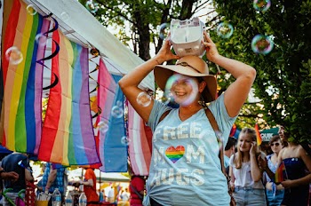 Photo of a Smiling Woman Holding Device on Head