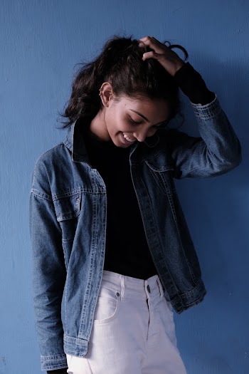 Photo of a Smiling Woman Touching  her Hair