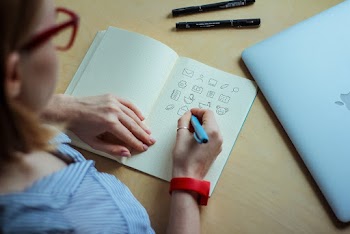Photo of a Woman Draws on Notebook