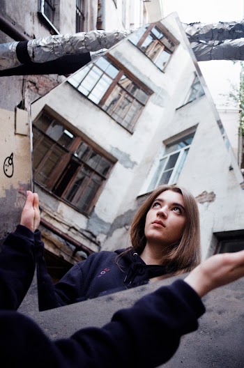 Photo of a Woman Holding a Mirror