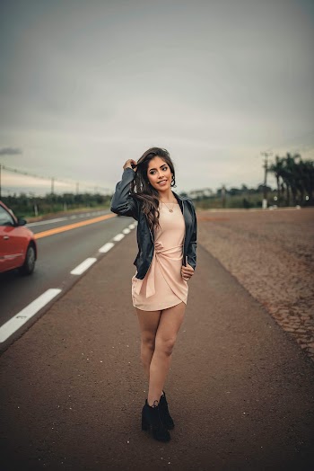 Photo of a Woman in Black Leather Jacket Standing on Road
