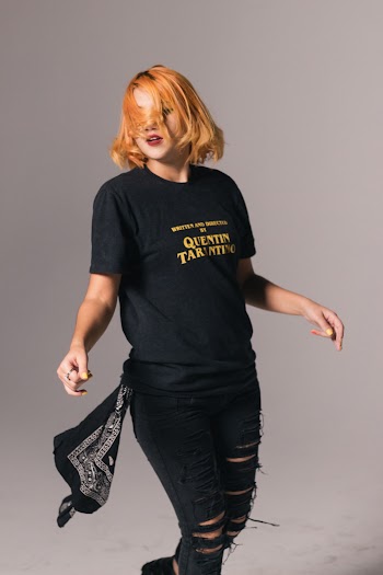 Photo of a Woman in Black T-Shirt Standing on a Grey Background
