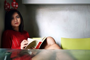 Photo of a Woman in Red Dress Holding a Book