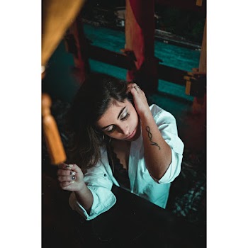 Photo of a woman in white top fixing her hair