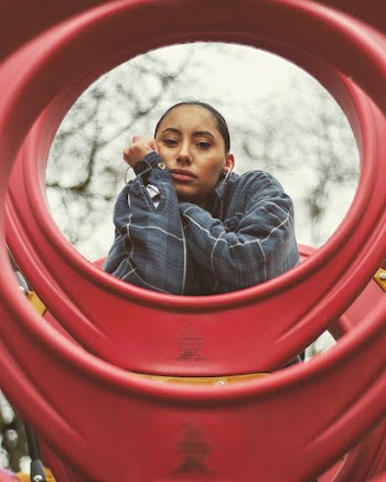 Photo of a Woman Leaning Beside Red Frame