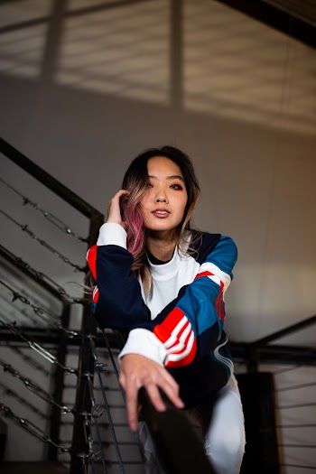 Photo of a Woman Leaning on Metal Railing