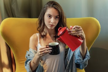 Photo of a Woman Pouring Pitcher on Cup