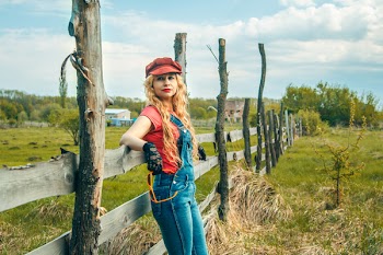 Photo of a Woman Resting Her Both Elbow on Wooden Fence