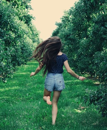 Photo of a Woman Running on Green Grass