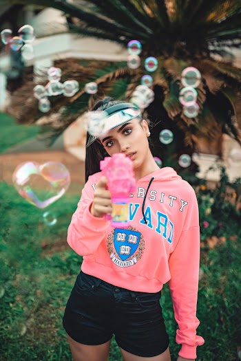 Photo of a woman shooting bubbles with a bubble gun