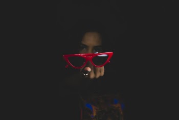 Photo of a Woman Showing Red Framed Sunglasses
