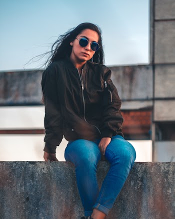 Photo of a Woman Sitting on a Ledge