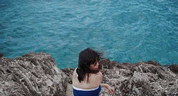 Photo of a Woman Sitting on Rock 
