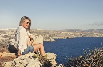 Photo of a Woman Sitting on the Cliff