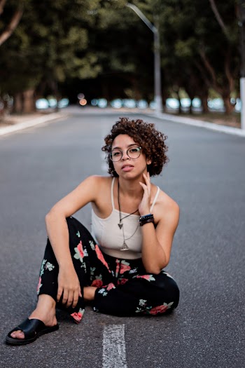 Photo of a Woman Sitting on the Road