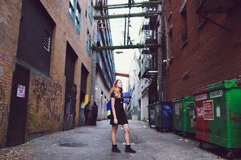 Photo of a Woman Standing Between Buildings