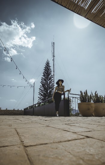Photo of a Woman Standing Near a Pot