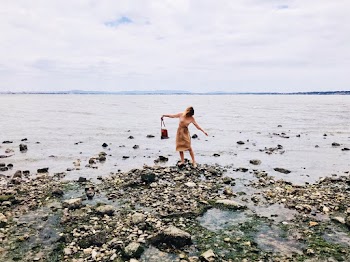 Photo of a woman Standing on a rocky seashore