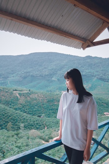 Photo of a Woman Standing on Balcony