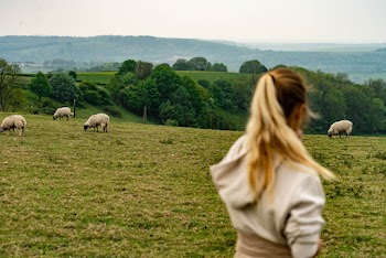 Photo of a Woman Standing on Grass Field