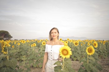 Photo of a Woman Standing on the Sunflower Field
