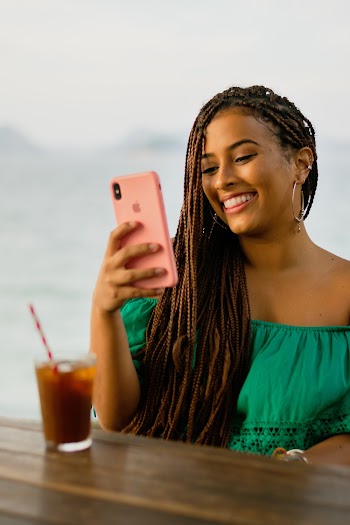 Photo of a Woman Using her Iphone