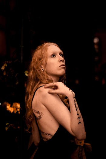 Photo of a Woman Wearing Black Sleeveless Dress