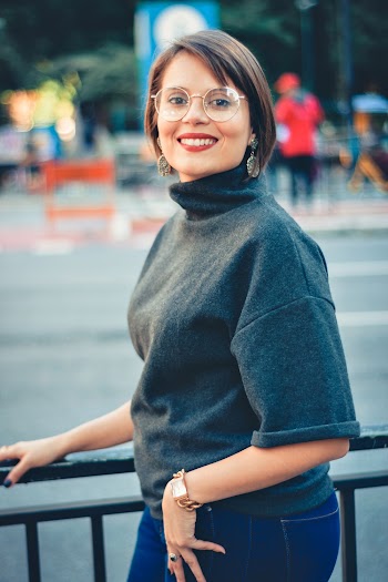 Photo of a Woman Wearing Eyeglasses Holding on Black Steel Handrail
