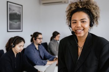 Photo of a Woman with Curly Hair Wearing a Black Headset · Free Stock Photo