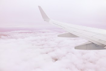 Photo of Airplane Wing Above the Clouds