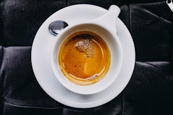 photo of almost emptied white teacup on saucer