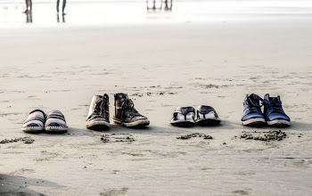 Photo of Assorted Pairs of Footwear on Sand