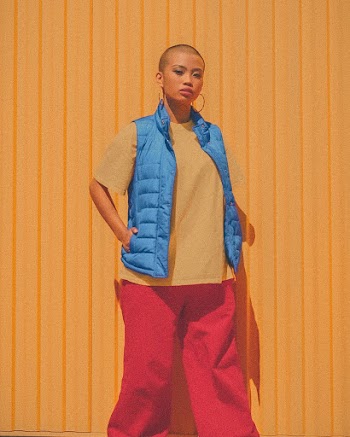 Photo of Bald Woman Posing In Front of Yellow Wall