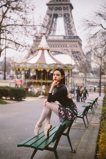 Photo of Ballerina Sitting on Green Bench Backrest With The Eiffel Tower in the Background