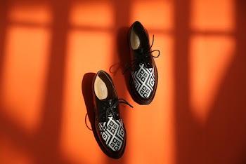Photo of Black Leather Shoes on Orange Background