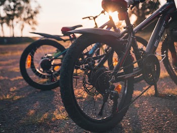 Photo of Black Mountain Bikes Parked on Gravel Road During Golden Hour