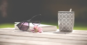 Photo of Black Sunglasses Beside Ceramic Mug