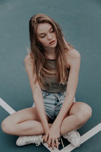 photo of blonde-haired woman sitting on floor