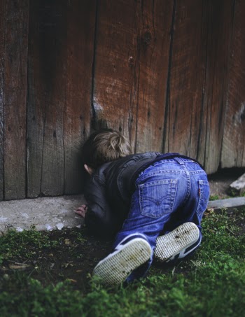 Photo of Boy Peeking on Brown Wooden Fence