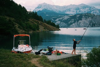 Photo of Boy Standing Near Lake Across the Mountain