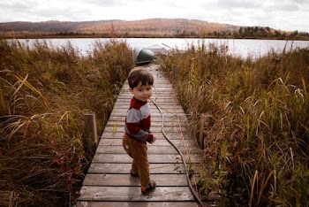 Photo of Boy Standing on Boardwalk
