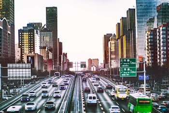 Photo of Cars on Road Between Buildings