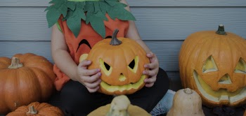 Photo of Child Holding Jack-o-lantern