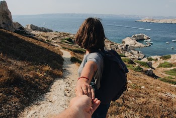 Photo of Couple Holding Hands While Standing Outdoors