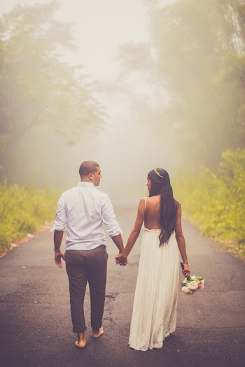 Photo of Couple Holding Hands While Walking Barefoot