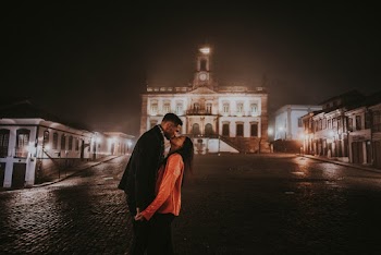Photo of Couple Kissing at Night with Building in the Background