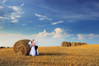 Photo of Couple Kissing Beside Hay Roll