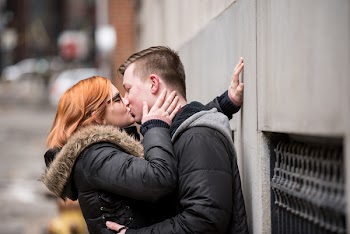 Photo of Couple Kissing Leaning on Wall